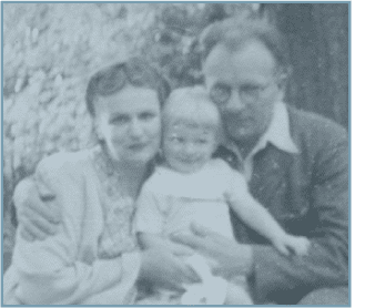 A man and woman holding a baby in front of another man.