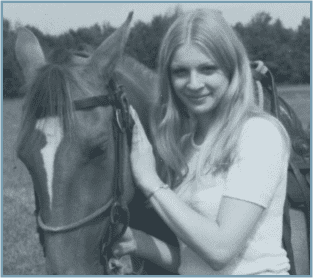 A woman standing next to two horses.